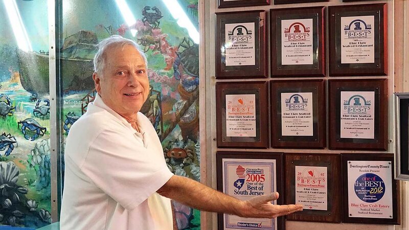 Norman showing many awards the restaurant has won